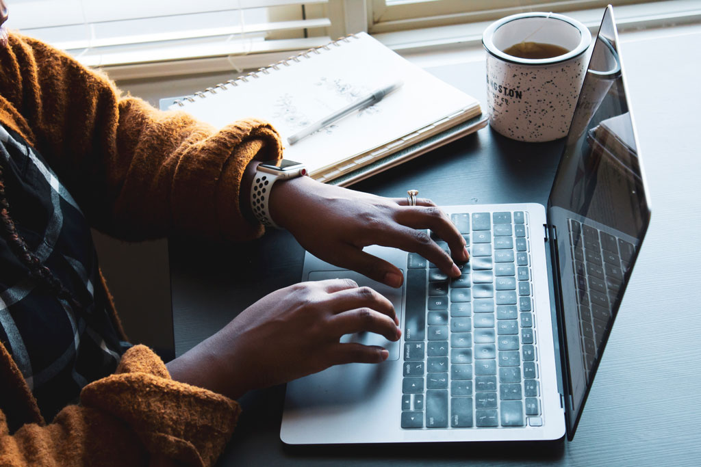 student typing on a laptop