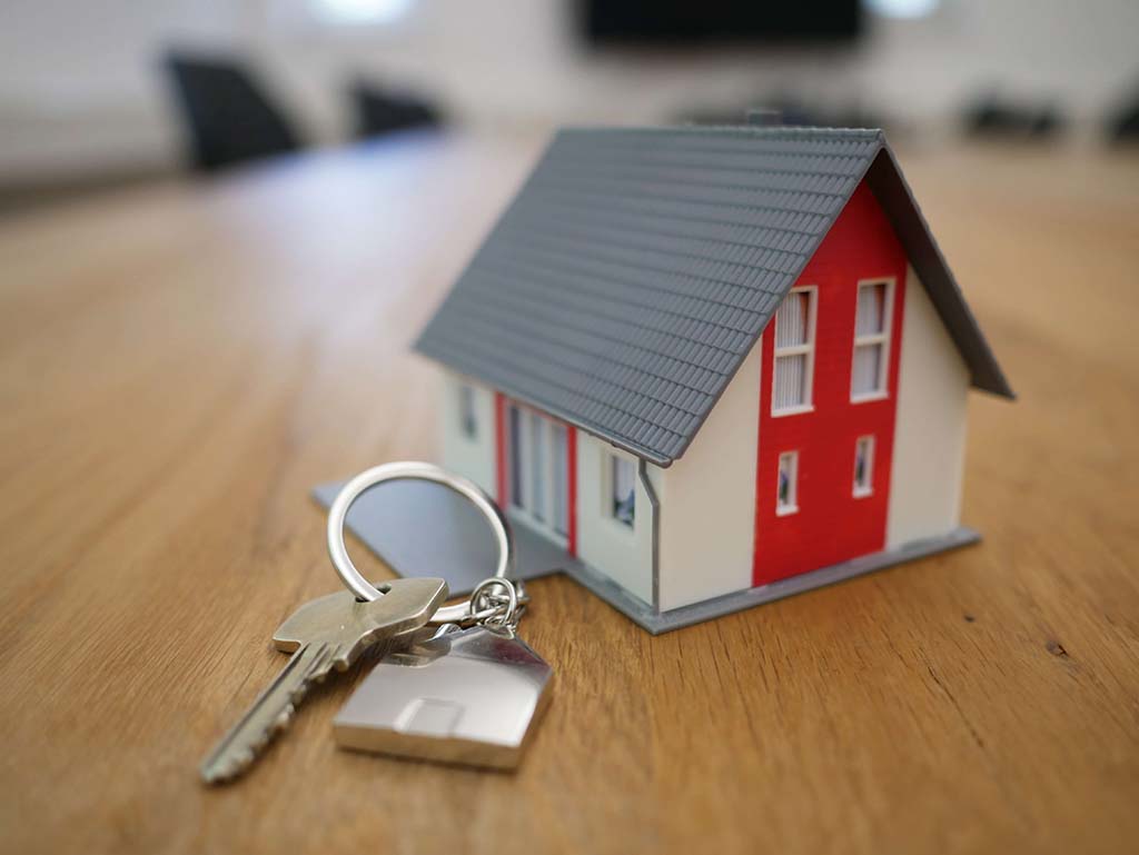 small model house with keys in foreground