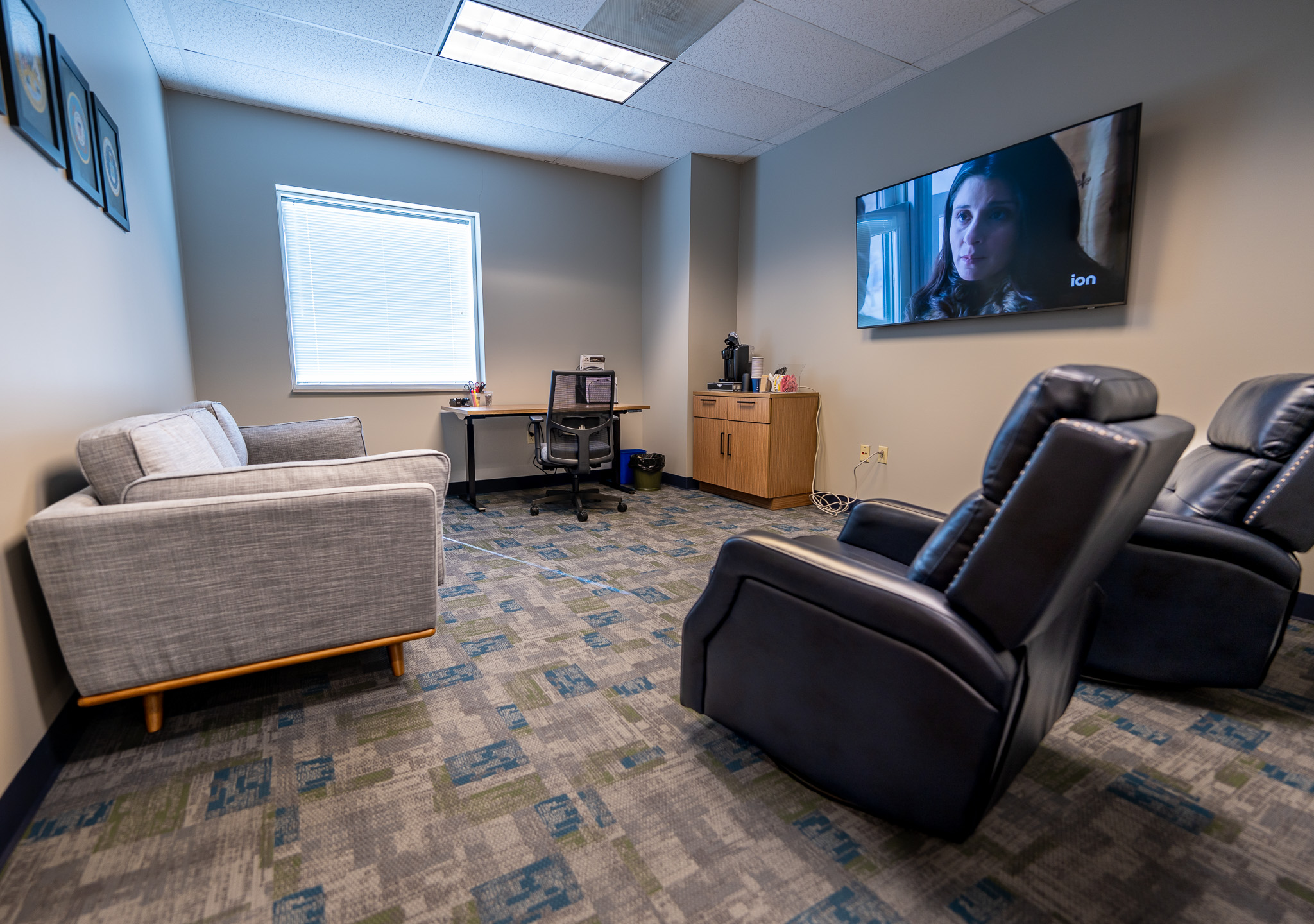 Lounge area with couches, recliners, desk, and coffee bar.