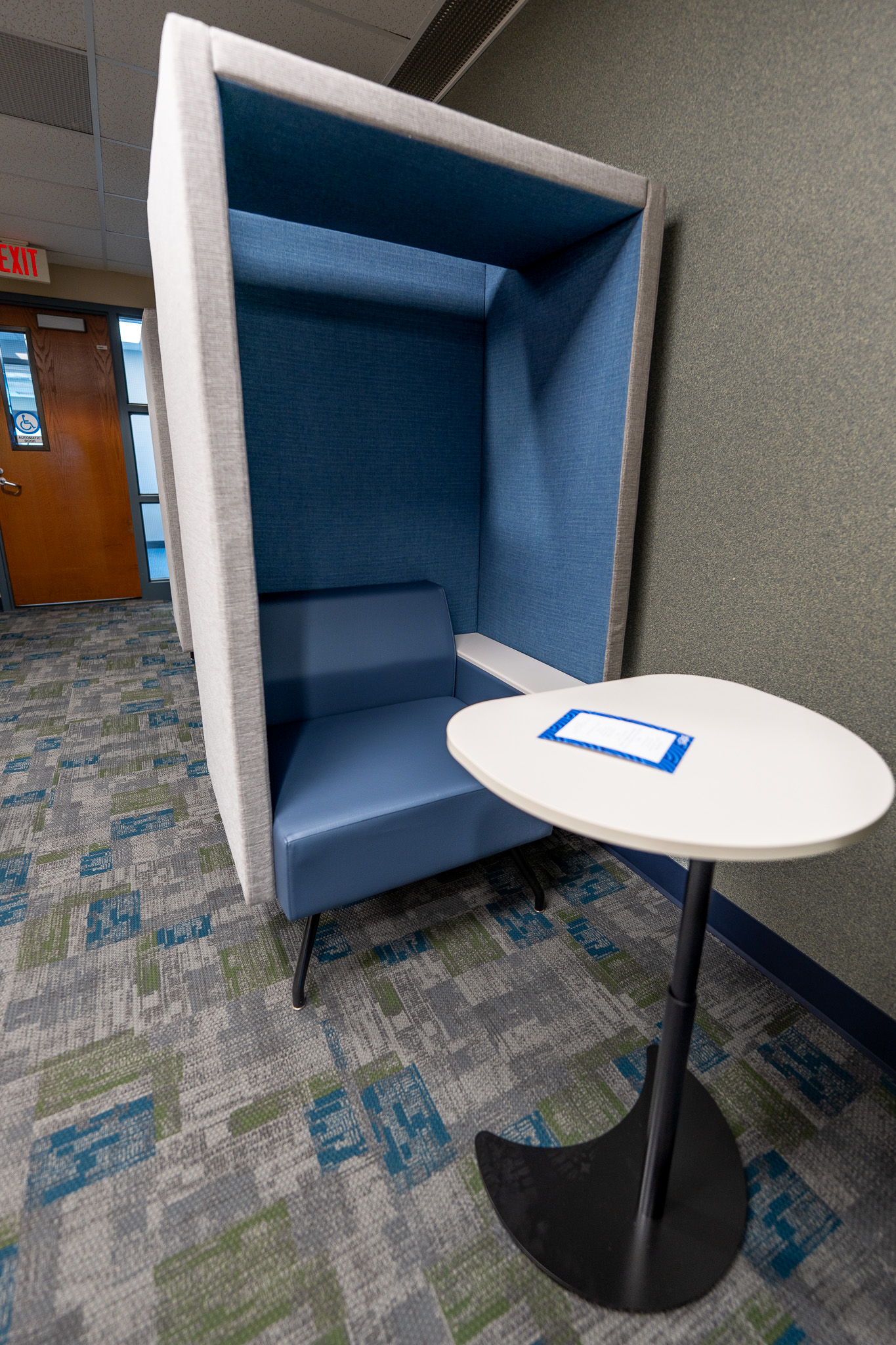 Noise cancelling cubical chair with desk space.